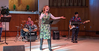 Female worshiper singing with hand raised