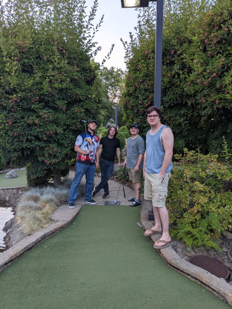 group of young adults play mini golf