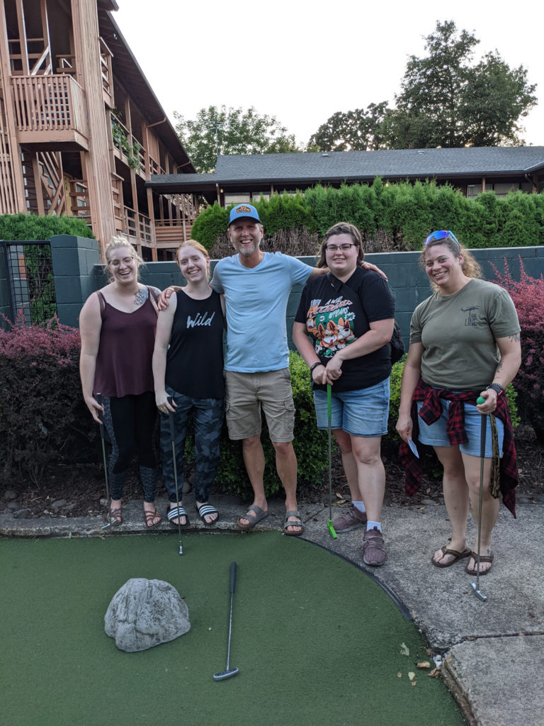 Group of smiling people at the young adult mini golf event