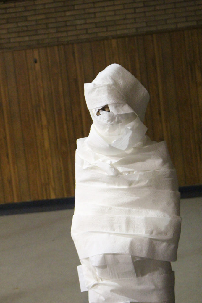 person wrapped in toilet paper like a mummy